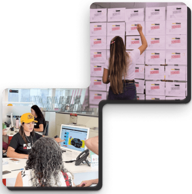 Duas fotos em estilo polaroid. Na foto de baixo, uma mulher com um boné amarelo e uma camisa preta e outra de costas, com cabelo cacheado, estão em frente a um laptop que exibe a imagem de um carro preto. Na foto de cima, uma mulher com cabelos longos está de costas, escrevendo em uma parede de caixas com a palavra "vendido" em cada uma delas.
